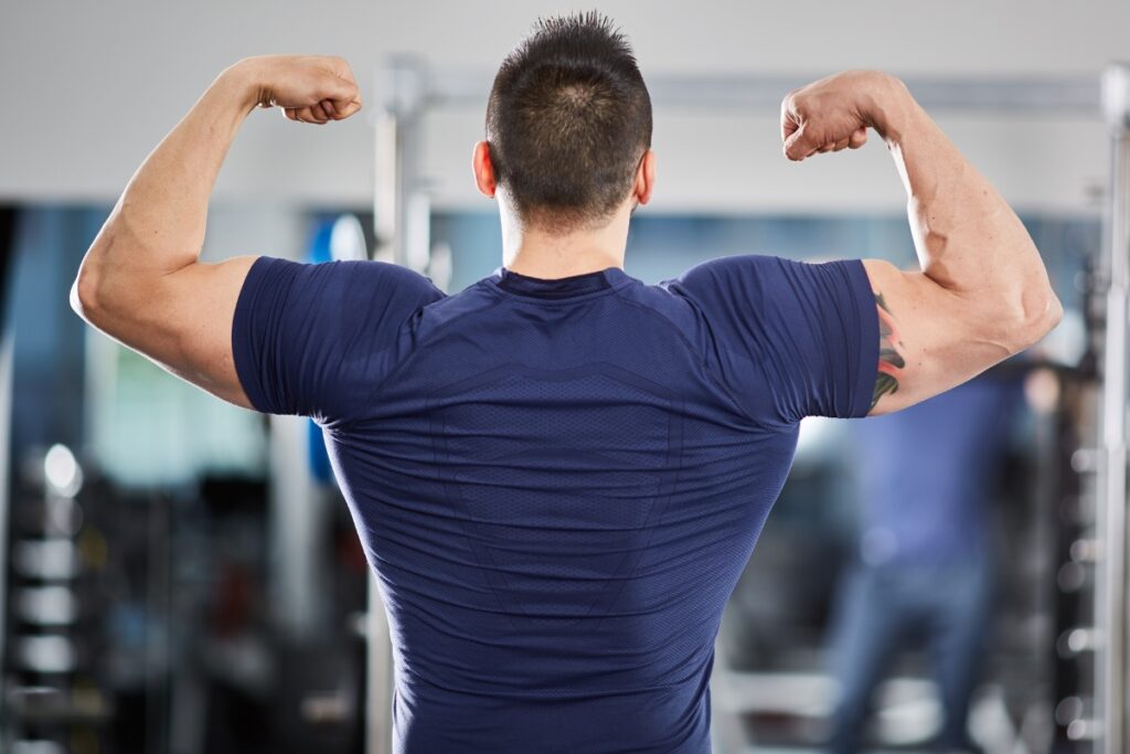 Protéine pour Masse Musculaire :Athlète satisfait regardant ses progrès devant un miroir